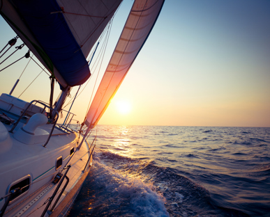 Leaning Prow Of A Yacht Sailing Into A Sunrise