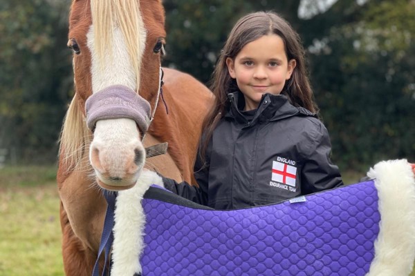 Amber Lewis In Her England Endurance Team Jacket With Her Horse In Front Of Her New Numnah Saddle Blanket