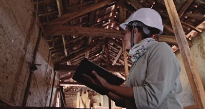 Person looking up at eaves in a barn 