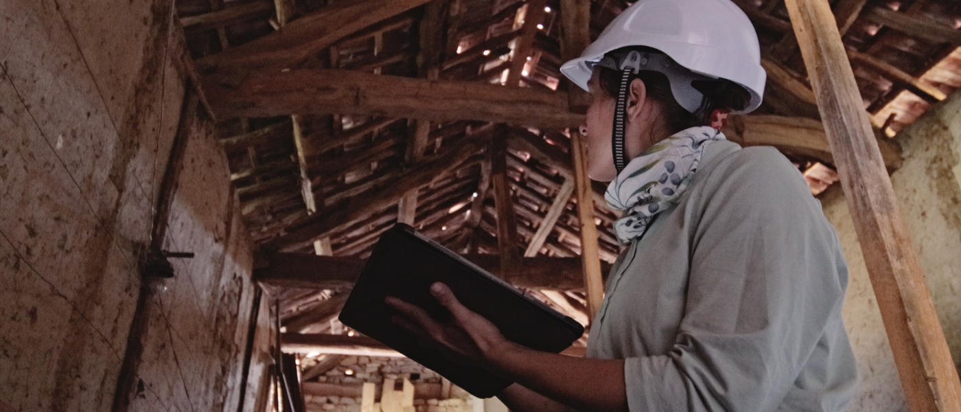 Person looking up at eaves in a barn 